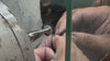 Jeweller's hands filing a silver ring held in a bench vice